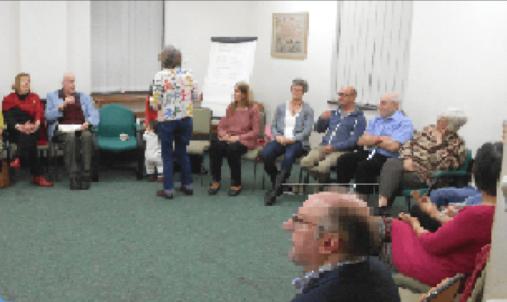 Adults and children sitting in a circle at Stoke Quaker Meeting House