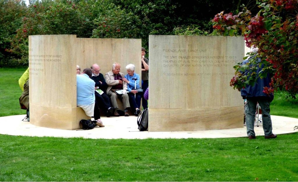 Photograph of the Quaker Memorial  with people on the built in seating and walking around.